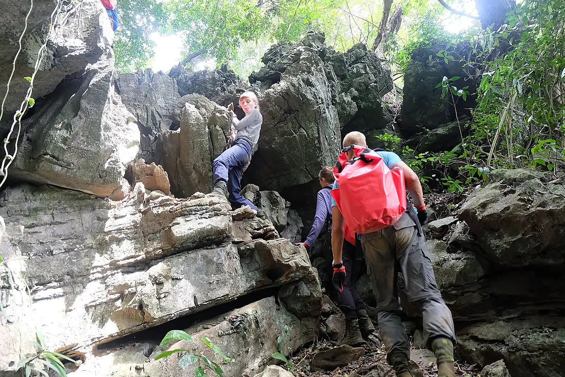 Climb up rocky hill to a small jungle opening